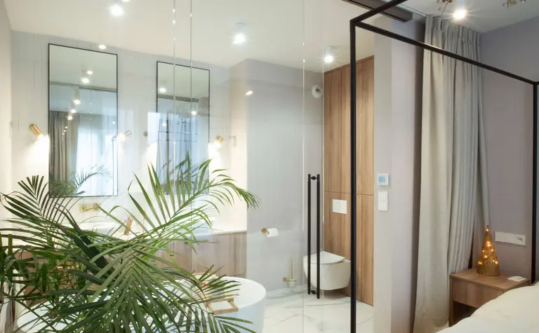 Wnętrze łazienki z białą wanną i drewnianymi detalami, styl quiet luxury.