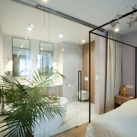 Wnętrze łazienki z białą wanną i drewnianymi detalami, styl quiet luxury.