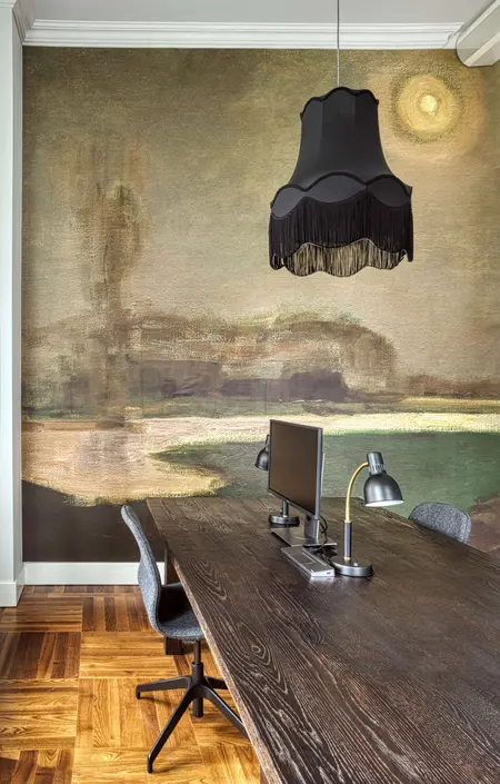 Wnętrze biura z eklektycznym stylem, nowoczesnym biurkiem oraz vintage lampą.