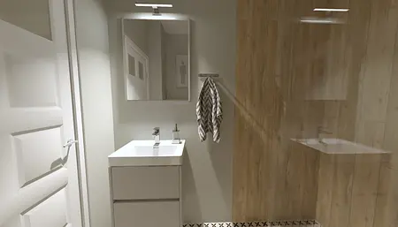 Współczesna łazienka z białą umywalką, lustrem i drewnianymi detalami.