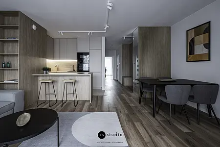 Wnętrze kuchni w stylu japandi z drewnianymi meblami i minimalistycznym oświetleniem.