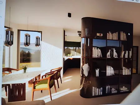 Wnętrze jadalni z nowoczesnym stołem, krzesłami i półką na książki.