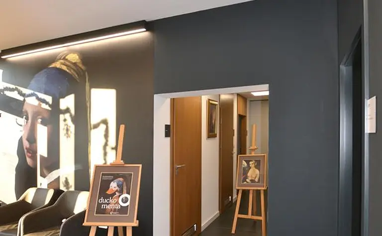 Przedpokój z minimalistycznym wystrojem, ciemnymi ścianami i drewnianymi akcentami.