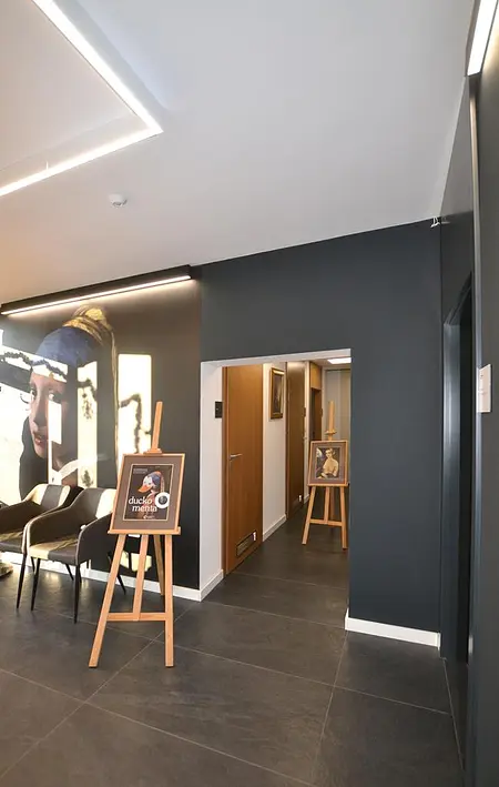 Przedpokój z minimalistycznym wystrojem, ciemnymi ścianami i drewnianymi akcentami.