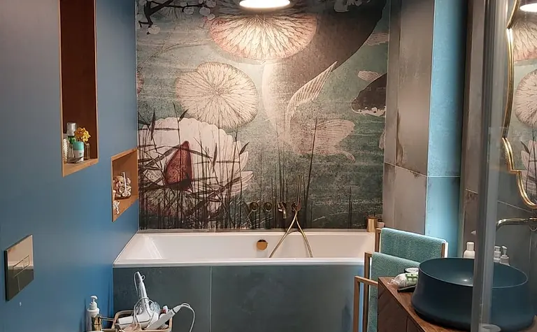 Eklektyczna łazienka z wanną, drewnianymi detalami i niebieską ścianą.
