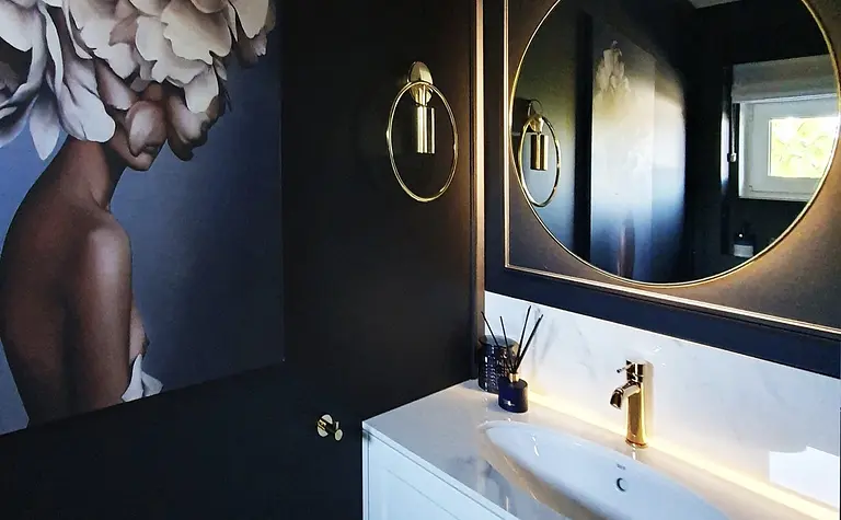 Wnętrze łazienki z białą umywalką i złotymi detalami, styl nowoczesny i glamour.