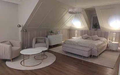 Sypialnia w stylu glamour z jasnym łóżkiem, lampami i eleganckim wystrojem.