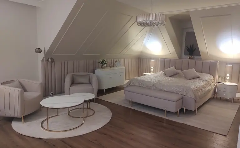 Sypialnia w stylu glamour z jasnym łóżkiem, lampami i eleganckim wystrojem.