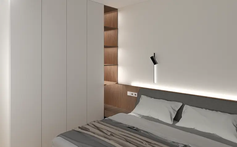 Sypialnia w stylu industrialnym i minimalistycznym z szarym łóżkiem i białymi ścianami.