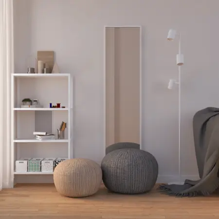 Minimalistyczny pokój z białą półką, szarymi pufami i dużym lustrem.