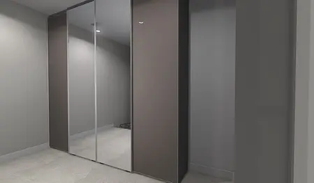 Garderoba z lustrzanymi drzwiami i szarymi ścianami w stylu japandi i minimalistycznym.