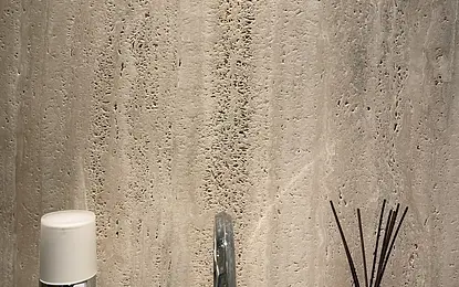 Jasna łazienka z trawertynem na ścianie, chromowaną baterią i dozownikiem by wedodesign.pl