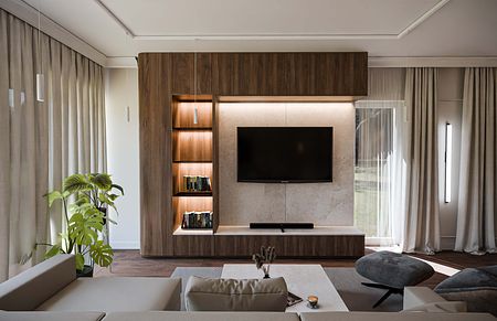 Nowoczesne wnętrze salonu z drewnianymi meblami i szaro-białymi dodatkami.