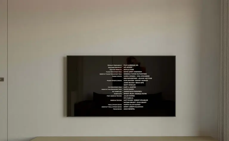Minimalistyczny salon z nowoczesnym telewizorem i drewnianymi meblami.