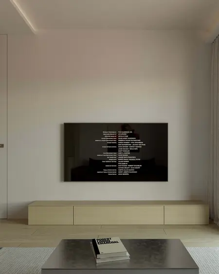 Minimalistyczny salon z nowoczesnym telewizorem i drewnianymi meblami.