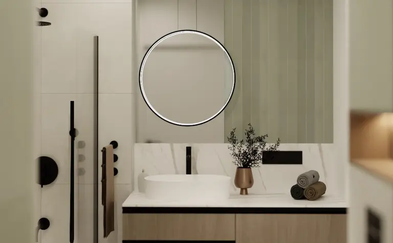 Nowoczesna łazienka z drewnianą szafką, okrągłym lustrem i minimalistycznym designem.