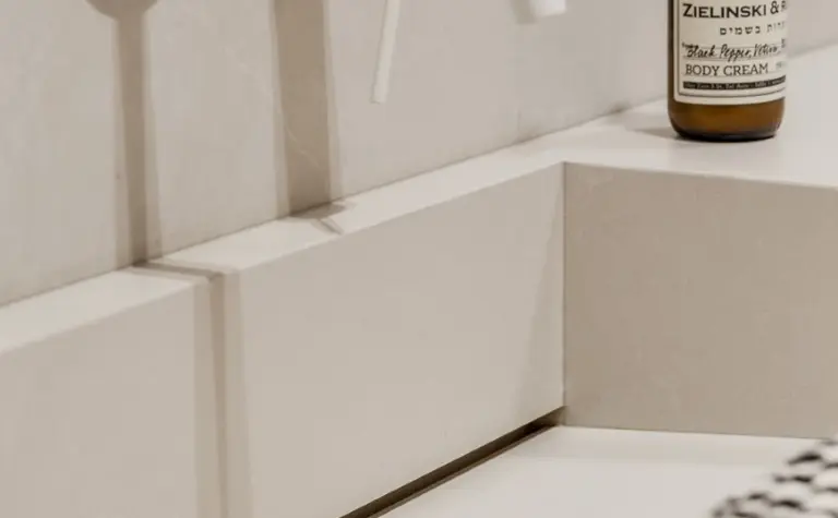 Minimalistyczna łazienka z białą umywalką, akcesoriami w stylu japandi i soft minimalizm.