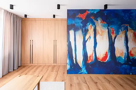 Garderoba z drewnianymi szafkami, niebieską ścianą i minimalistycznym wystrojem.