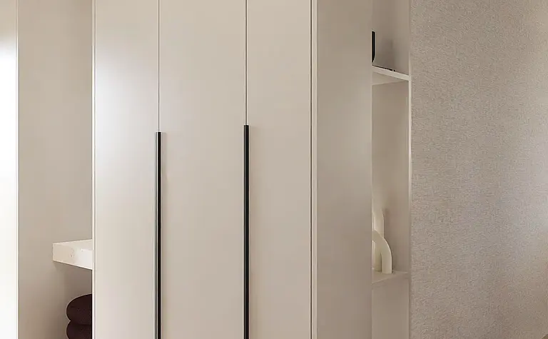 Garderoba w stylu japandi, minimalistycznym z beżowymi meblami i drewnianą podłogą.