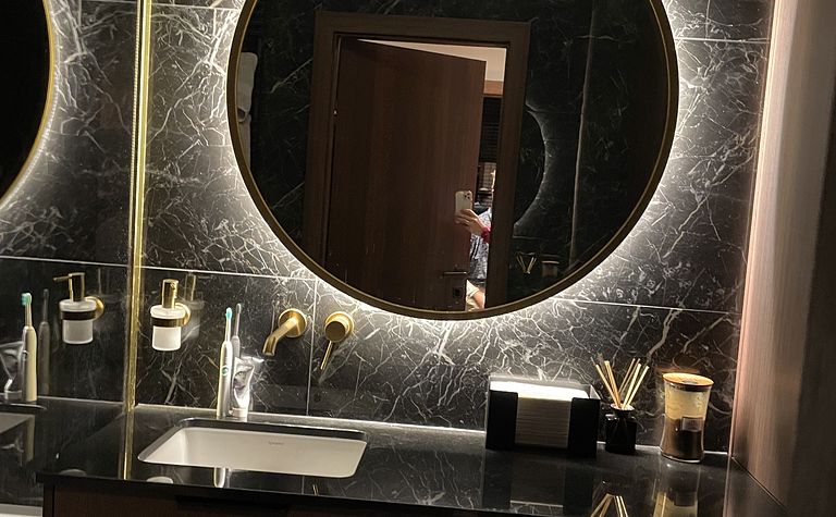 Nastrojowa łazienka z ciemnym kamiennym gresem płytkami i złotymi bateriami by wedodesign.pl
