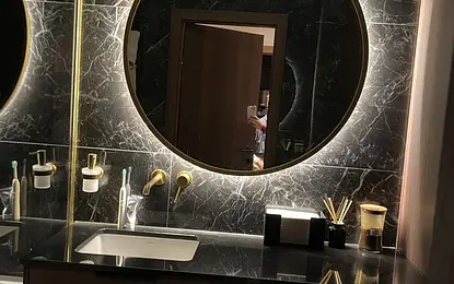 Nastrojowa łazienka z ciemnym kamiennym gresem płytkami i złotymi bateriami by wedodesign.pl