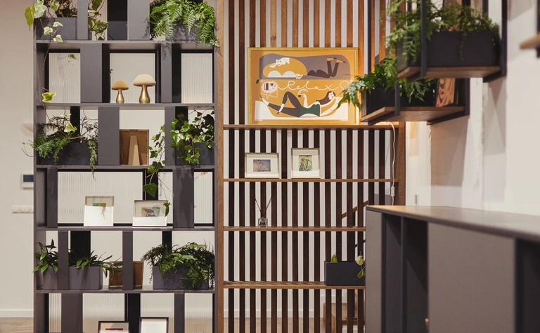 Wnętrze z eklektycznymi półkami, roślinami i drewnianymi akcentami. Styl dopamine decor, industrialny, rustykalny, vintage.
