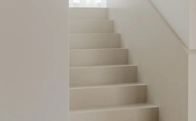 Jasne schody w minimalistycznym wnętrzu z elementami japandi i soft minimalizmu.