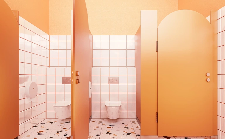 Wnętrze toalety w stylu dopamine decor z pomarańczowymi akcentami i nowoczesnymi płytkami.