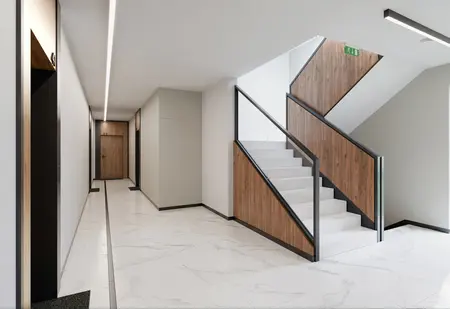 Przedpokój z elementami glamour i industrialnymi, białe płytki i drewniane wykończenia.