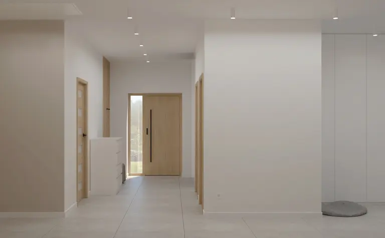 Przedpokój w stylu japandi i minimalistycznym z białymi ścianami i drewnianymi akcentami.