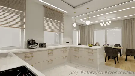 Kuchnia z beżowymi meblami, białym blatem i nowoczesnym oświetleniem.