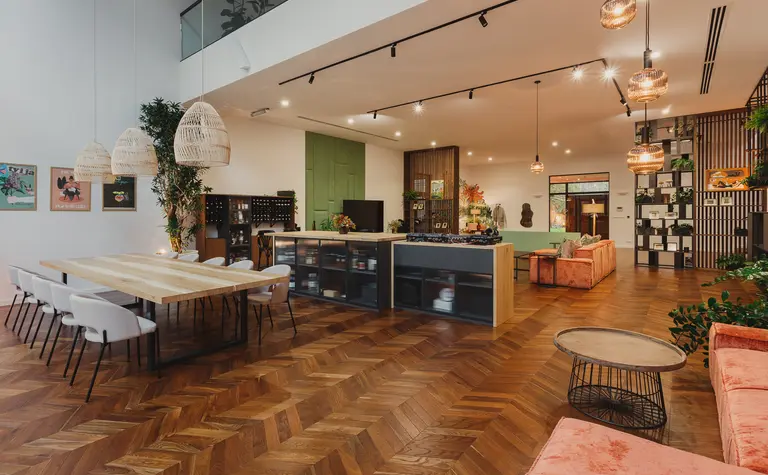 Wnętrze z drewnianym stołem, różowymi sofami i roślinami w stylu dopamine decor, eklektycznym, industrialnym, rustykalnym, vintage.