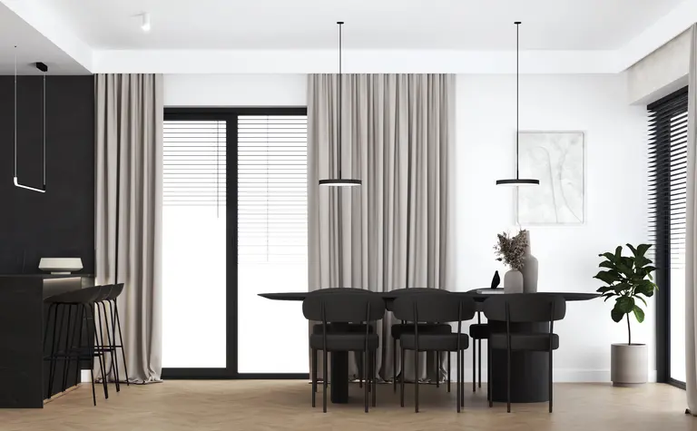 Wnętrze jadalni z czarnym stołem, beżowymi zasłonami, minimalistycznym designem i roślinami.