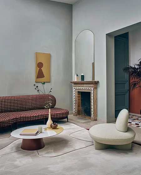 Wnętrze salonu z art deco i minimalistycznym designem, brązowa sofa, okrągły stół.