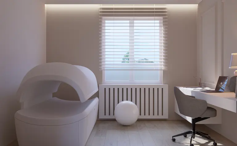 Wnętrze gabinetu z minimalistycznym biurkiem, szarym fotelem i nowoczesnym designem.