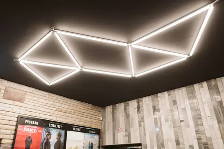 Wnętrze z minimalistycznym oświetleniem LED i nowoczesną kamienną ścianą w stylu współczesnym.