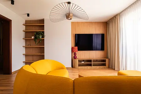 Wnętrze salonu w stylu boho, eklektycznym, nowoczesnym z żółtą sofą i drewnianymi akcentami.