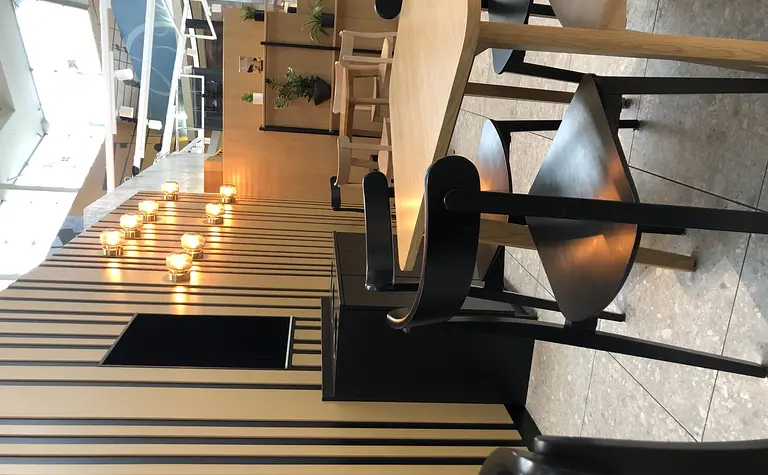 Wnętrze kawiarni w stylu japandi, minimalistycznym i nowoczesnym z drewnianymi detalami.