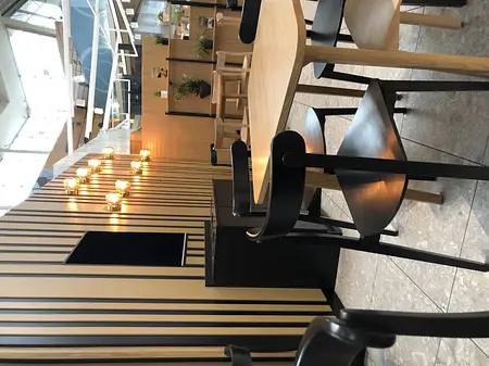 Wnętrze kawiarni w stylu japandi, minimalistycznym i nowoczesnym z drewnianymi detalami.