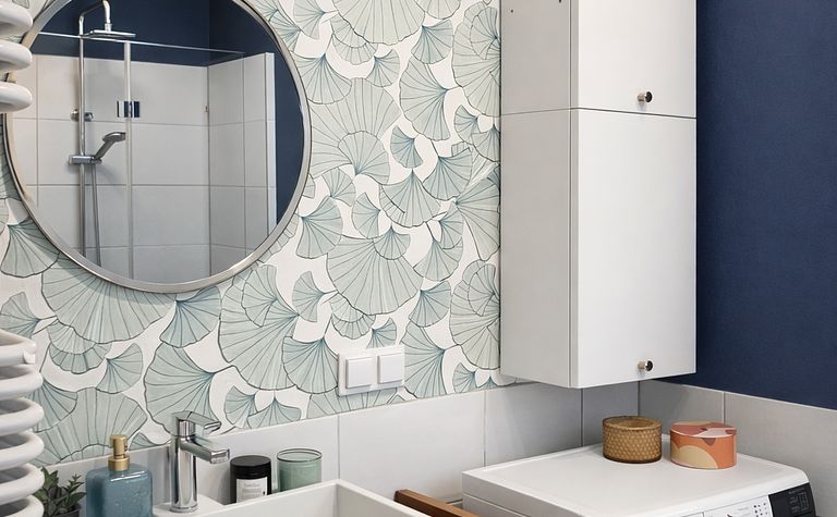 Wnętrze łazienki z białą umywalką, niebieskimi ścianami i eklektycznym stylem