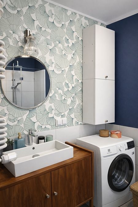 Wnętrze łazienki z białą umywalką, niebieskimi ścianami i eklektycznym stylem