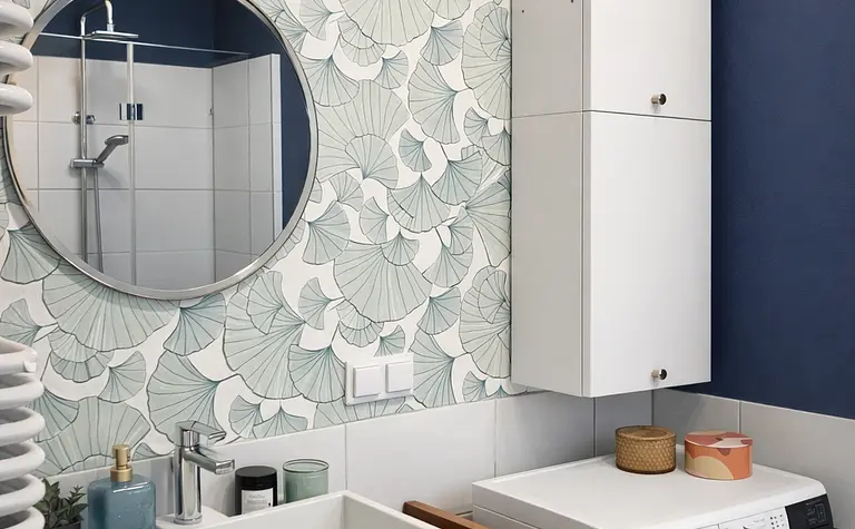 Wnętrze łazienki z białą umywalką, niebieskimi ścianami i eklektycznym stylem