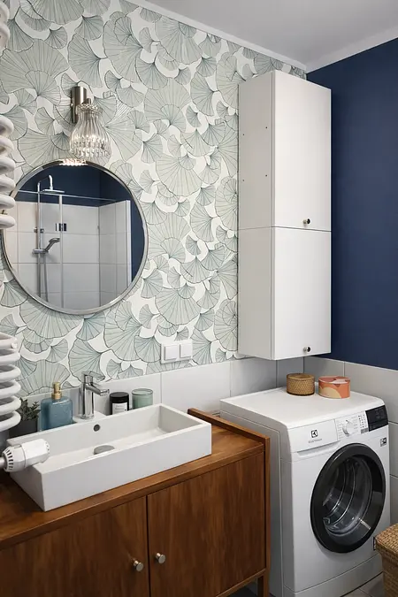 Wnętrze łazienki z białą umywalką, niebieskimi ścianami i eklektycznym stylem