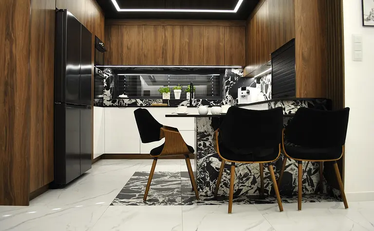 Wnętrze kuchni z drewnianymi meblami i czarnym blatem, nowoczesny design.