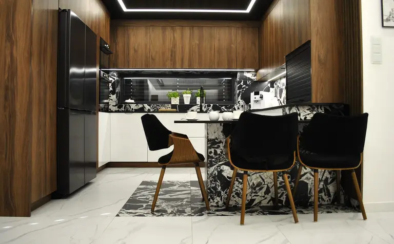 Wnętrze kuchni z drewnianymi meblami i czarnym blatem, nowoczesny design.