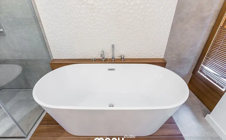 Wnętrze łazienki z białą wanną, drewnianymi detalami, w stylu industrialnym, minimalistycznym i skandynawskim.