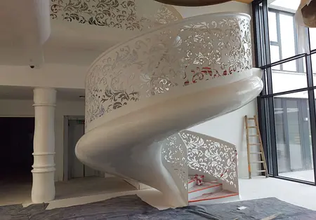 Wnętrze z białymi schodami spiralnymi i dużymi oknami, nowoczesny projekt.