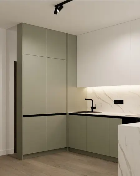 Kuchnia z nowoczesnymi zielonymi meblami, białym blatem i czarnymi akcentami.