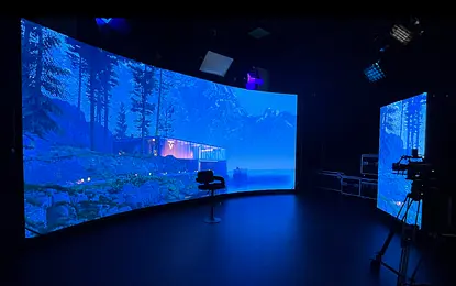 Wnętrze studia z panoramicznym ekranem i widokiem na jezioro w stylu industrialnym.