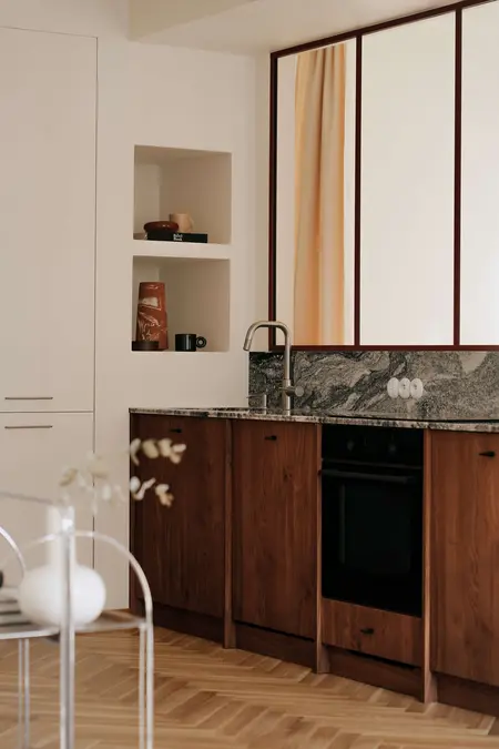 Kuchnia w stylu quiet luxury z drewnianymi meblami, minimalistycznym designem i vintage akcentami.